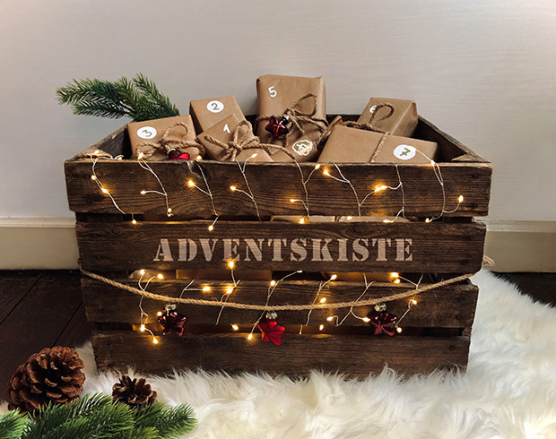 Kleine Geschenke und bunte Weihnachtsdeko auf rustikalem Holz