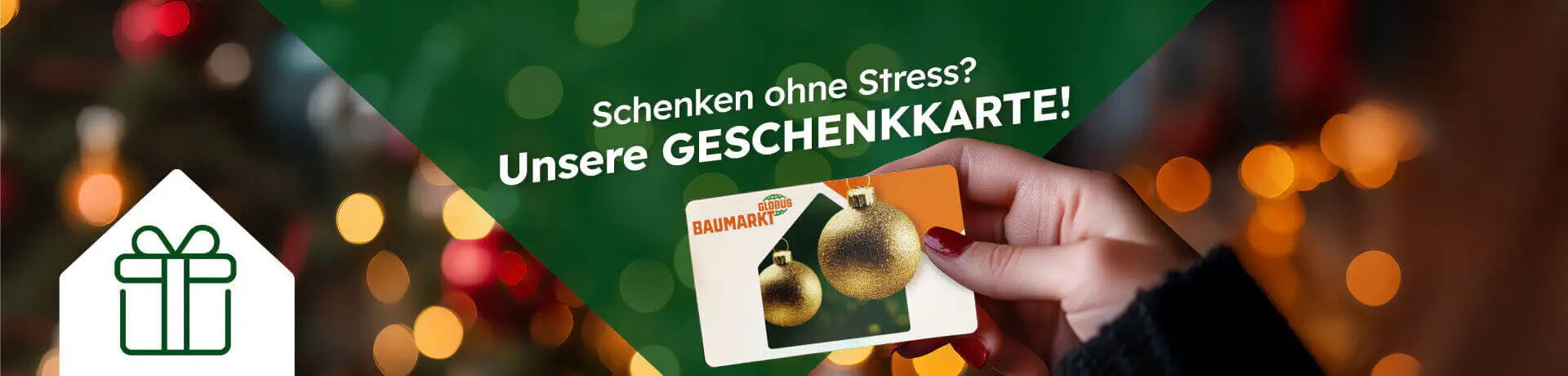 Hand hält eine Globus-Baumarkt-Geschenkkarte mit goldenen Kugeln; Text im Bild: „Schenken ohne Stress? Unsere GESCHENKKARTE!“