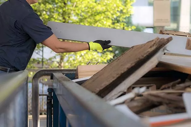 Sondermüll wird in einen großen Container geworfen.
